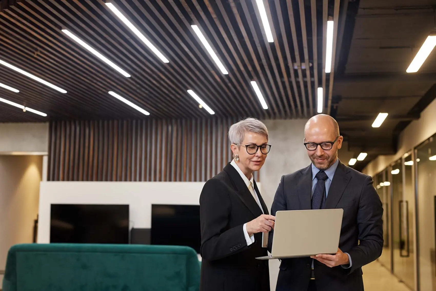 business directors discussing a project or plan while looking at a laptop in the office