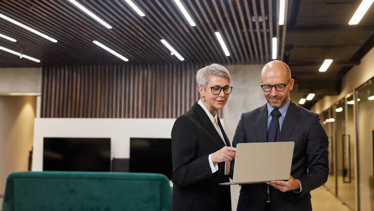 coweorkers-chatting-over-laptop-in-office