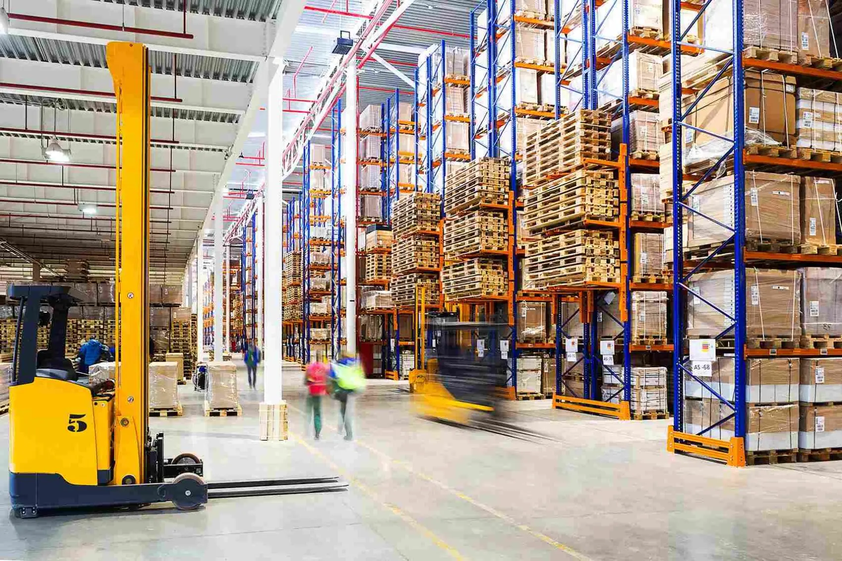 warehouse where pallets are stored and construction workers are walking