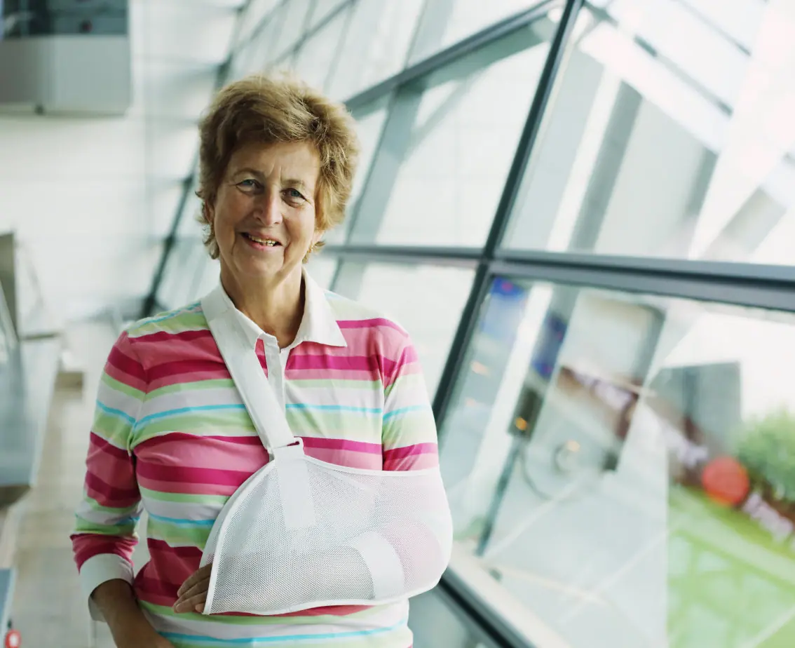 older woman with an arm injury in a sling at the hospital