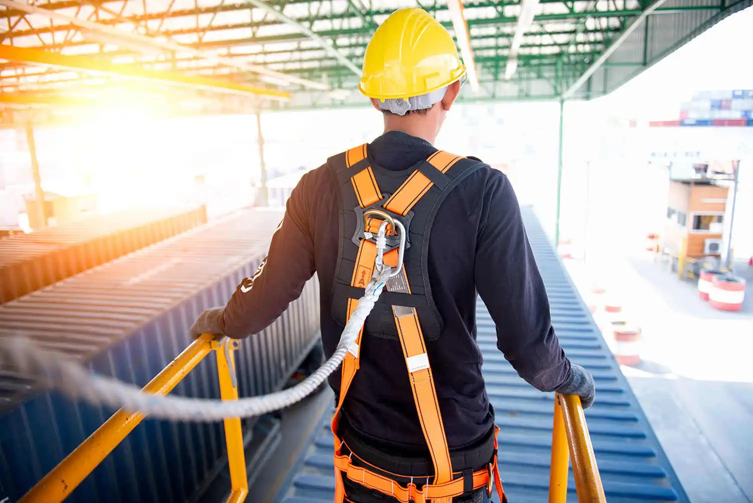 construction worker on site looking at shipping containers