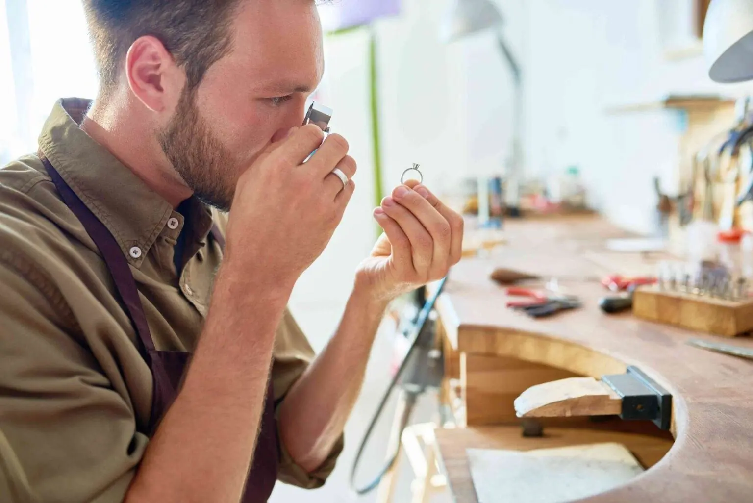 pawn shop worker inspecting ring for price