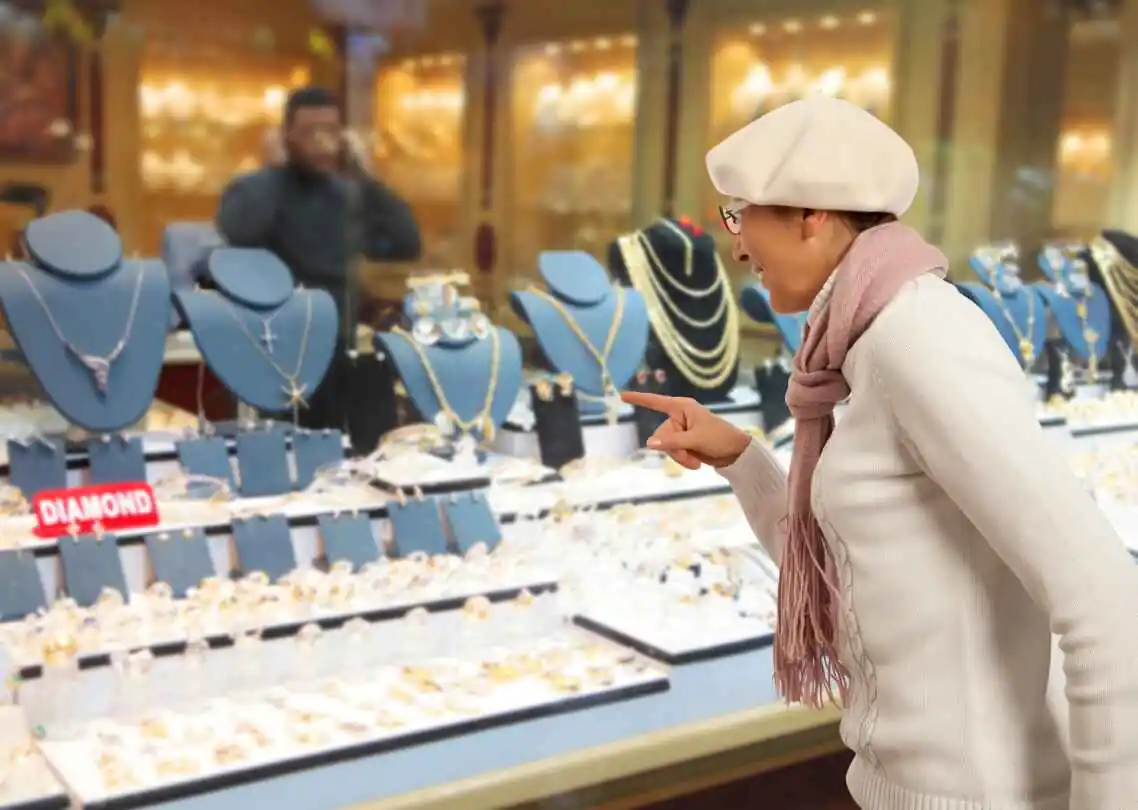 customer at pawn shop looking at diamond necklaces and gold jewelry