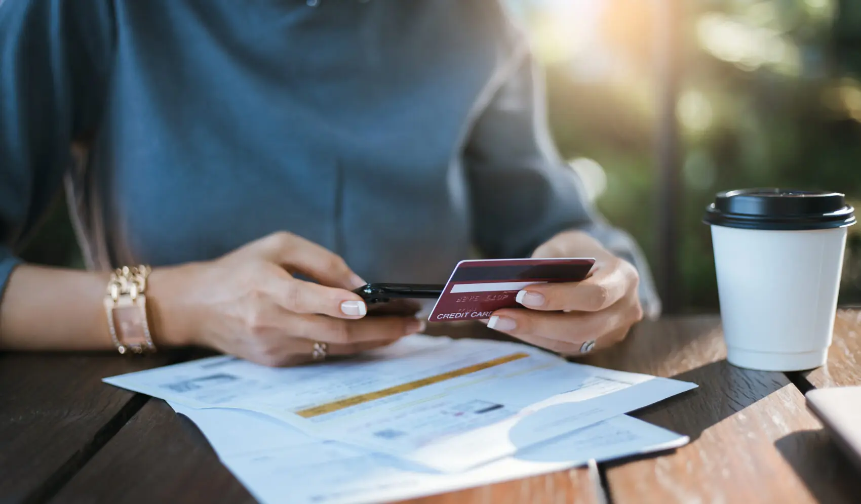 woman using smart phone and credit card for paying bills