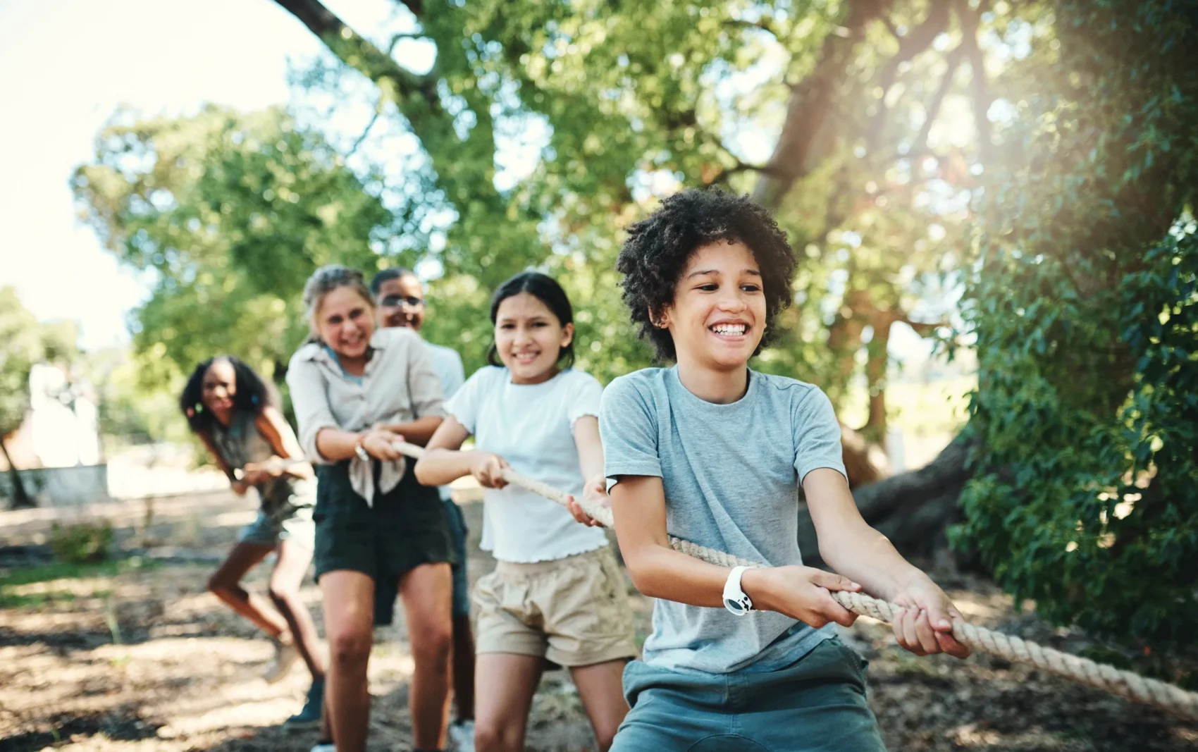 Children participating in a tug-of-war activity at summer camp, illustrating group activities and risks addressed by camp insurance.