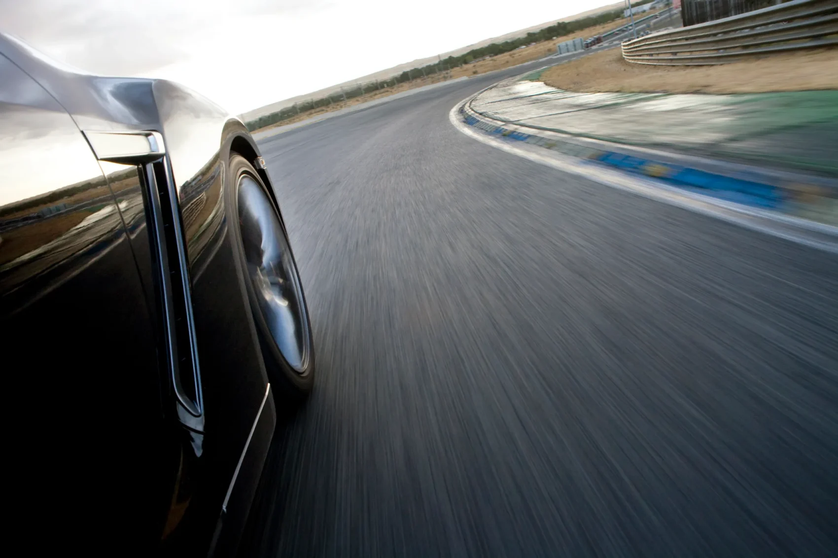 Close-up of a sports car navigating a track day circuit at speed, highlighting the need for track day insurance coverage
