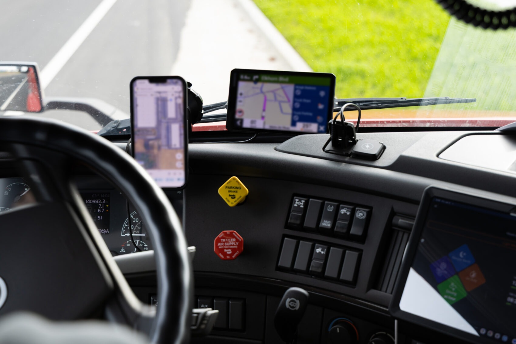Truck driver using GPS and mobile navigation apps in cab during long haul — telematics data and commercial auto insurance premium management