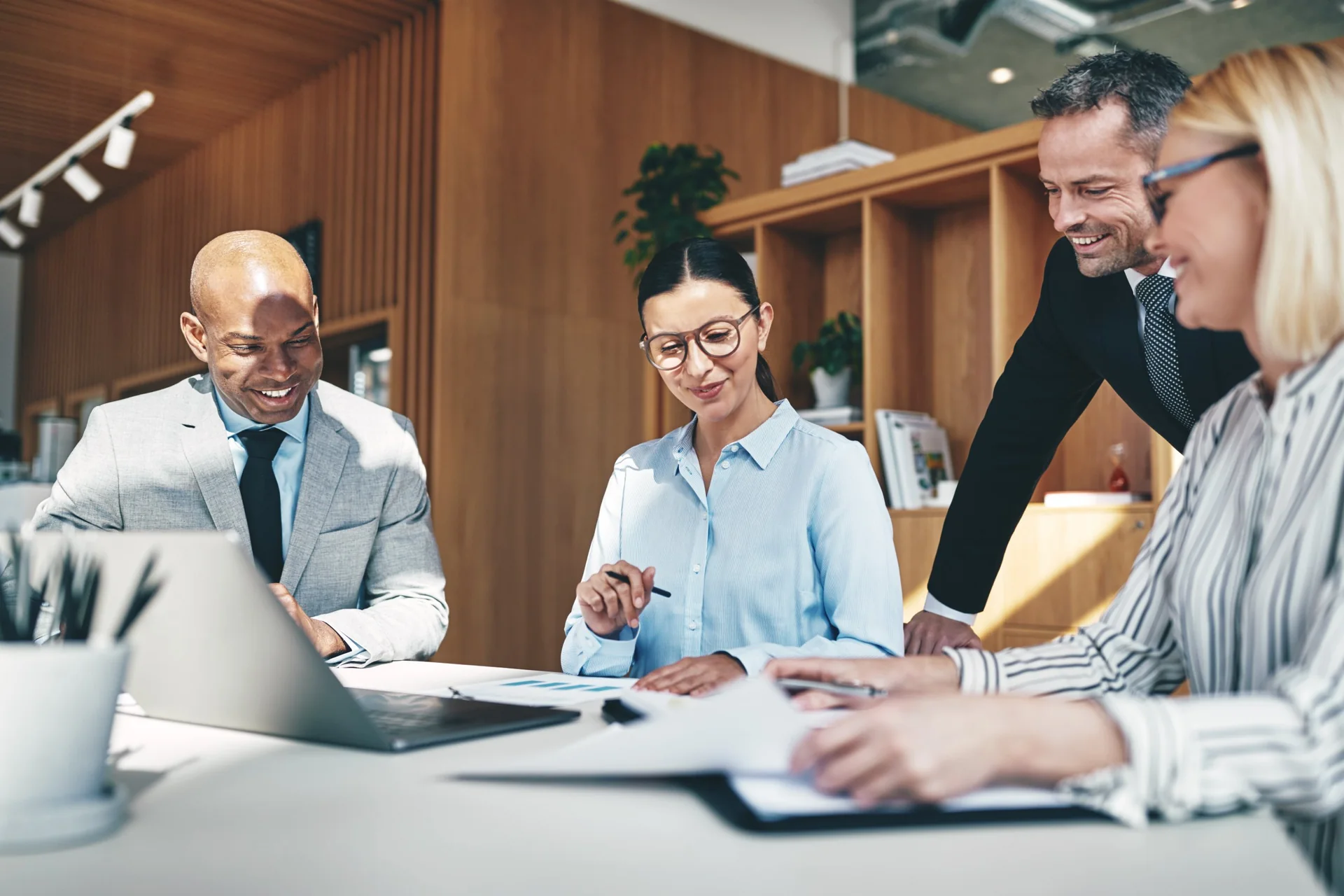Four colleagues reviewing documents at a table